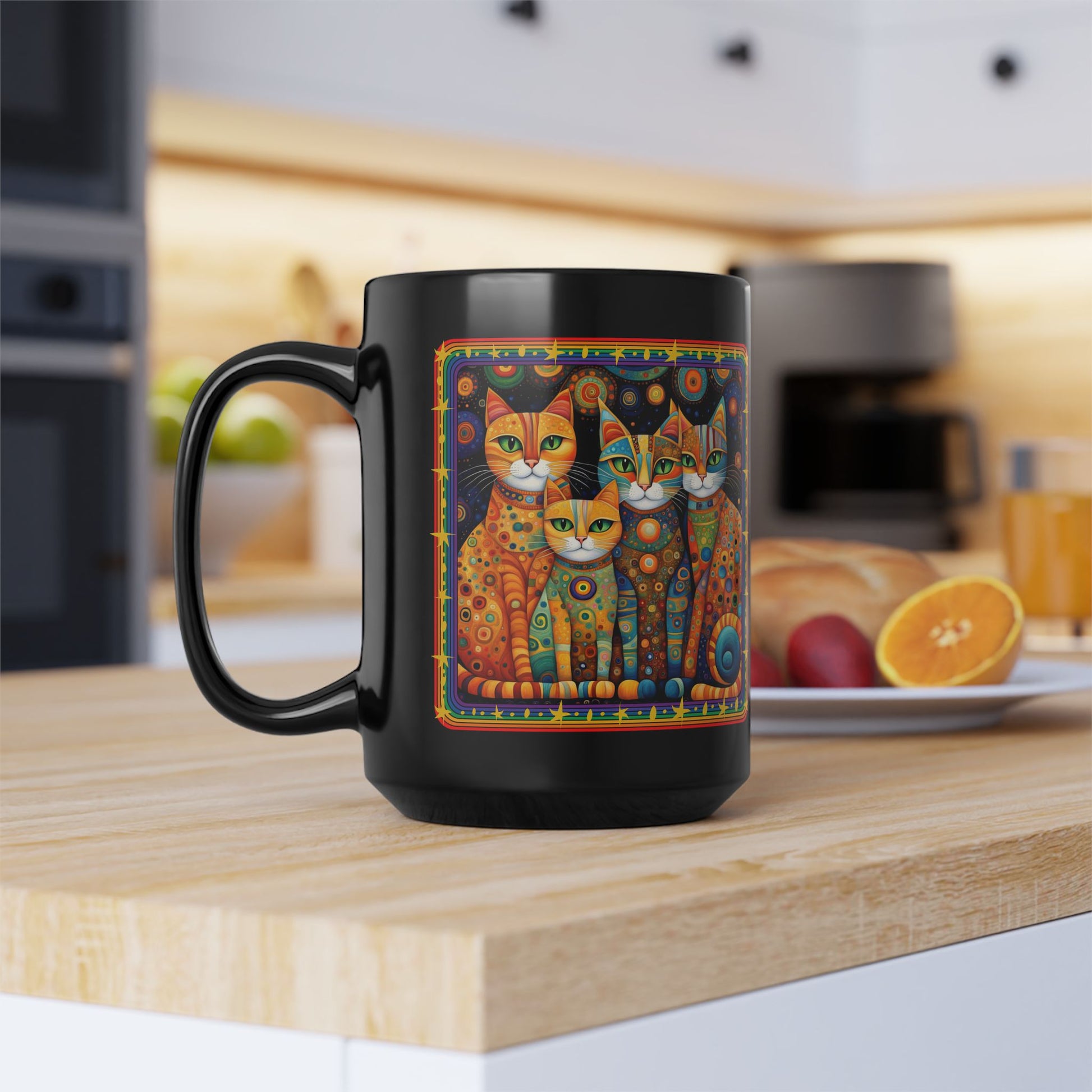 A black mug sitting on a kitchen counter featuring a bright and colorful Klimt-inspired patchwork cat design.